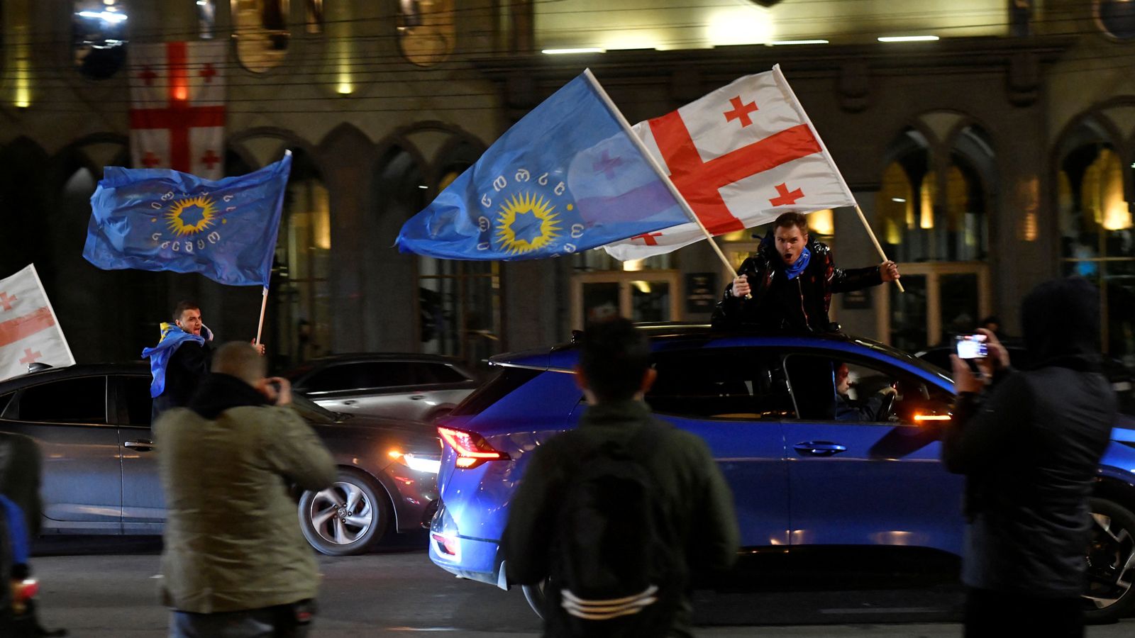 Supporters of the Georgian Dream party wave flags after win. Pic: Reuters