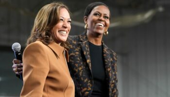 Former first lady Michelle Obama, right, and Democratic presidential nominee Vice President Kamala Harris address the crowd in the overflow space of a campaign rally at the Wings Event Center in Kalamazoo, Mich. (AP Photo/Jacquelyn Martin)