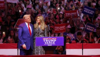 Republican presidential nominee and former U.S. President Donald Trump embraces Melania Trump during a rally at Madison Square Garden, in New York, U.S., October 27, 2024. REUTERS/Andrew Kelly