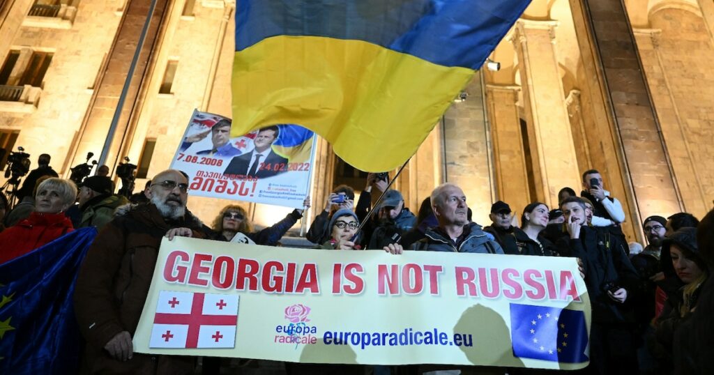 Une banderole "La Géorgie n'est pas la Russie", surmontée d'un drapeau ukrainien, le 28 octobre 2024 dans une manifestation pro-européenne à Tbilissi