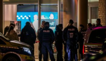 Polizeibeamte und Rettungsdienst stehen vor dem Kino in der Krefelder Innenstadt. Foto: Christoph Reichwein/dpa