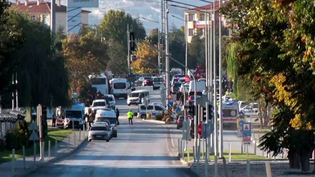 Rettungsteams und Polizeibeamte sind am Stadtrand vor dem Unternehmensgelände im Einsatz. Foto: Uncredited/IHA/AP/dpa