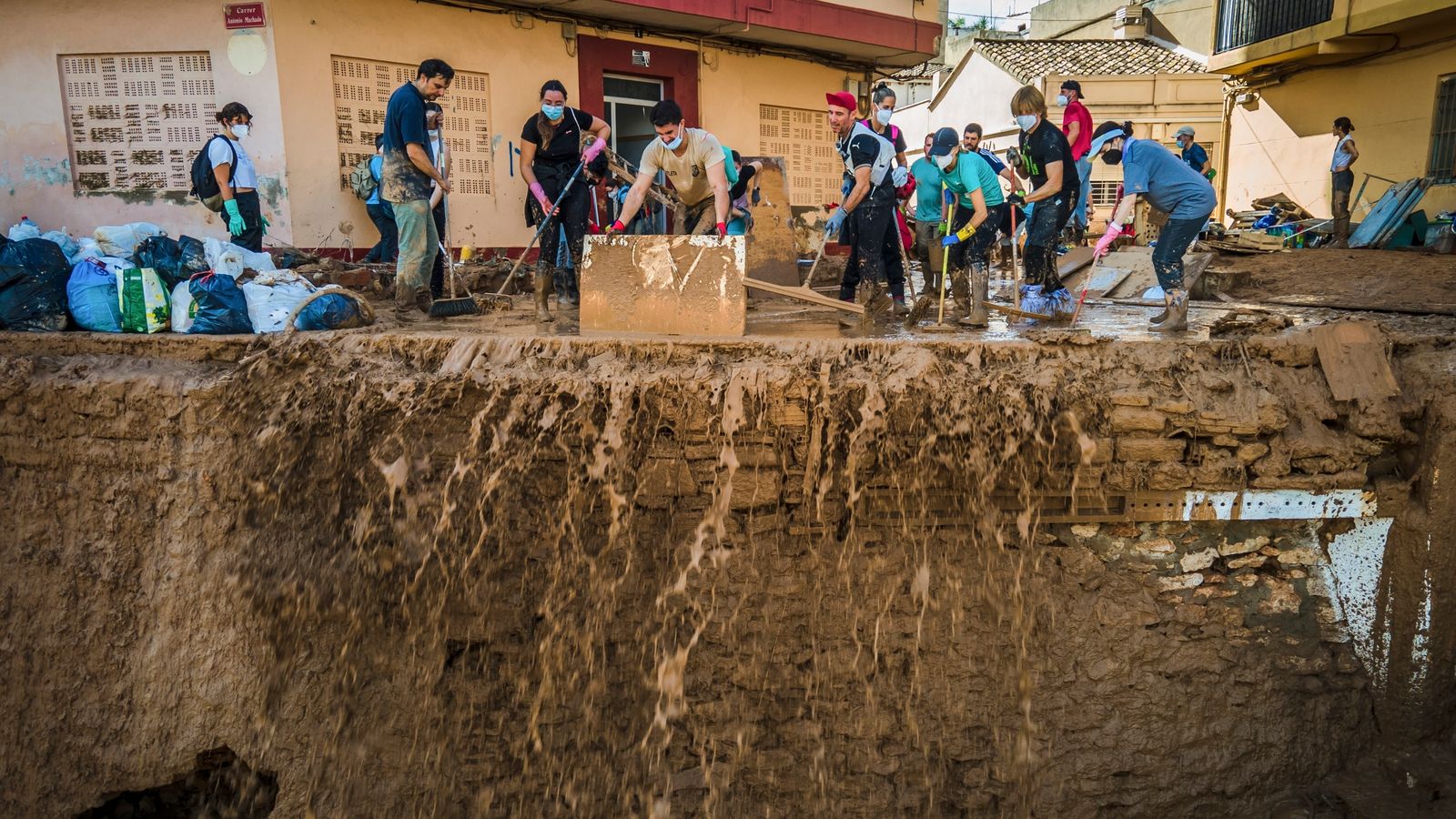 Volunteers and residents cleanup the mud four days after flash floods swept away everything in their path in Paiporta, outskirts of Valencia, Spain, Saturday, Nov. 2, 2024.(AP Photo/Angel Garcia)