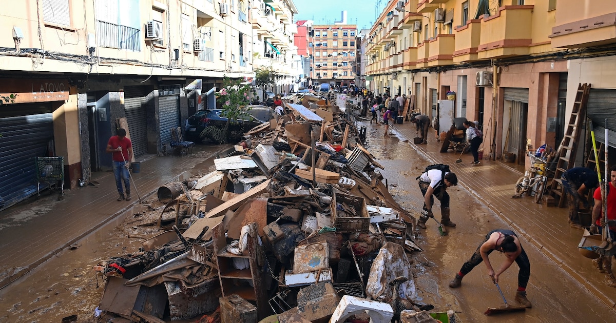 Des habitants empilent des débris dans une rue de Paiporta, après des inondations dévastatrices, le 1er novembre 2024 dans la région de Valence, en Espagne