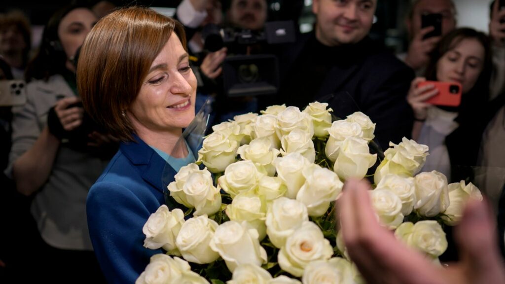 Maia Sandu holds a bouquet of flowers while standing with her supporters on election night. Pic: AP