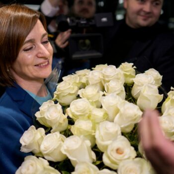 Maia Sandu holds a bouquet of flowers while standing with her supporters on election night. Pic: AP