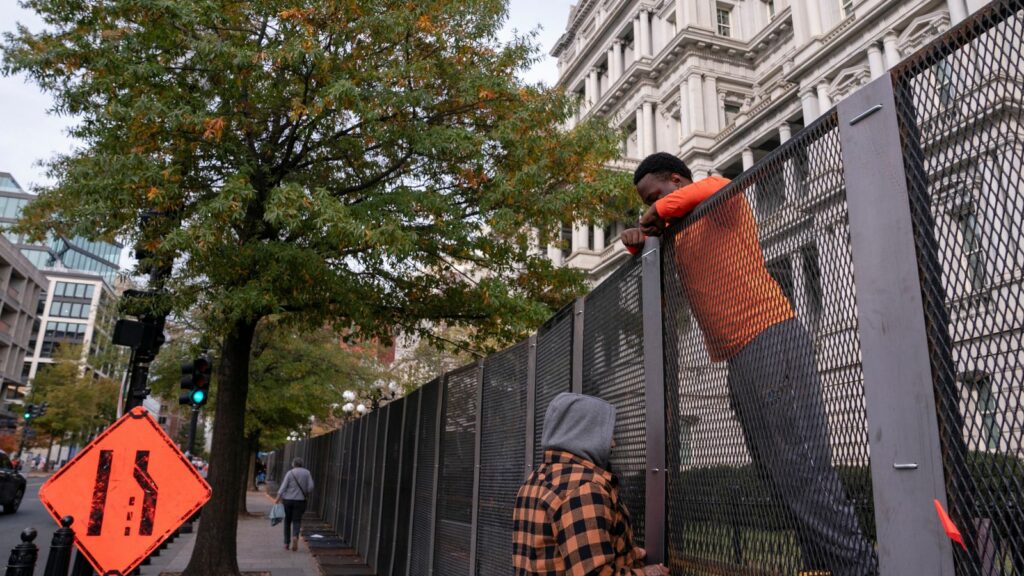 Workers put up security fencing near the White House on Monday. Pic: Reuters