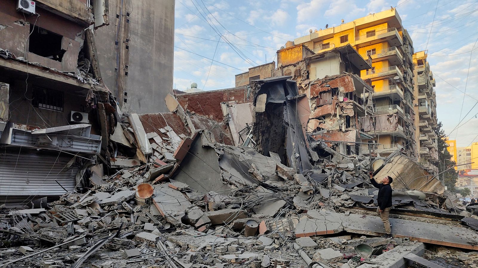 A man stands on the rubble of damaged buildings, in the aftermath of Israeli strikes on Beirut's southern suburbs, amid the ongoing hostilities between Hezbollah and Israeli forces, Lebanon, November 7, 2024. REUTERS/Mohammed Yassin TPX IMAGES OF THE DAY