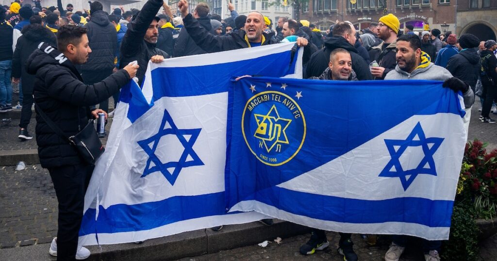 Les supporters du Maccabi Tel Aviv brandissent des drapeaux sur la place du Dam avant le match de football de la Ligue Europa entre l'Ajax et le Maccabi Tel Aviv, à Amsterdam, le 7 novembre 2024