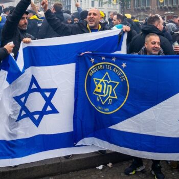 Les supporters du Maccabi Tel Aviv brandissent des drapeaux sur la place du Dam avant le match de football de la Ligue Europa entre l'Ajax et le Maccabi Tel Aviv, à Amsterdam, le 7 novembre 2024