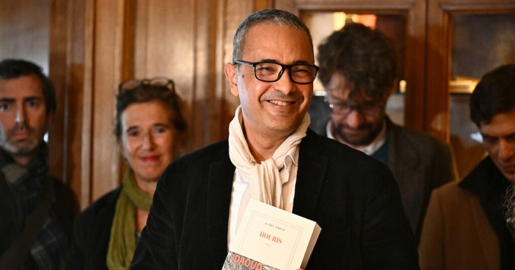 L'écrivain franco-algérien Kamel Daoud (c), lauréat du prix Goncourt pour son roman "Houris", au restaurant Drouant à Paris, le 4 novembre 2024