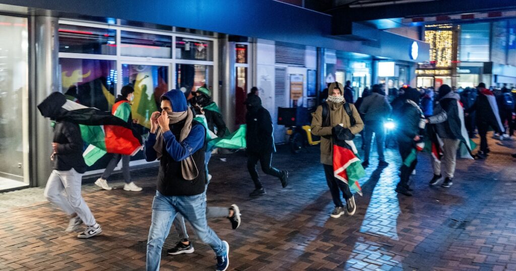 Des manifestants courent avec des drapeaux palestiniens lors d'une manifestation pro-palestinienne pendant Ajax - Maccabi Tel-Aviv à Anton de Komplein.