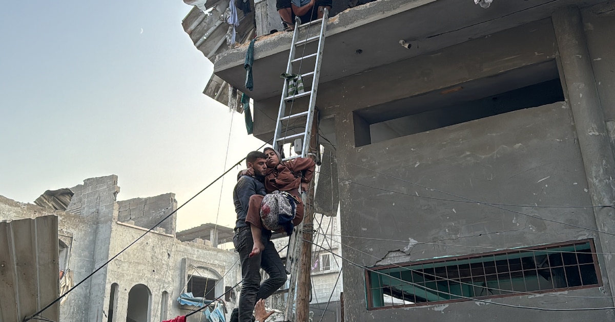 Un Palestinien porte secours à une femme blessée par une frappe dans le camp de réfugiés de Jabalia, dans le nord de la bande de Gaza, le 7 novembre 2024