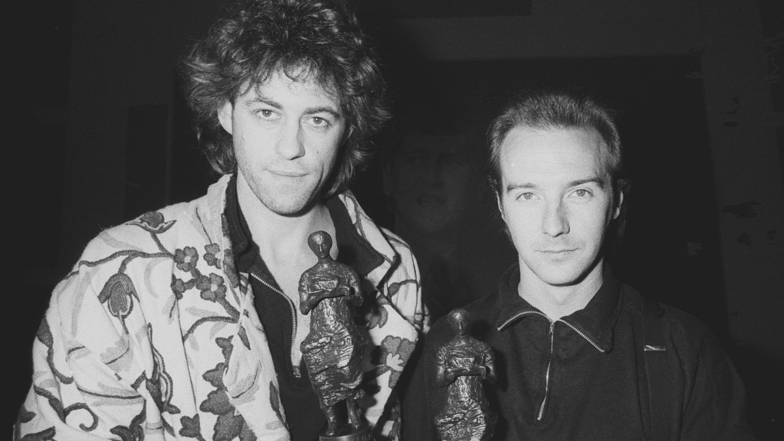 Midge Ure (R), 31, of the rock group Ultravox, with Bob Geldof at the Ivor Novello Awards for 1984 at the Grosvenor House Hotel, London. The pair won a joint award for the Band Aid single 'Do They Know It's Christmas?"