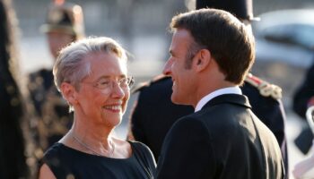 France's President Emmanuel Macron (R) and France's Prime Minister Elisabeth Borne chat as they wait for the arrival of the Indian Prime Minister ahead of a dinner at The Louvre Museum in Paris, on July 14, 2023. (Photo by Ludovic MARIN / AFP)