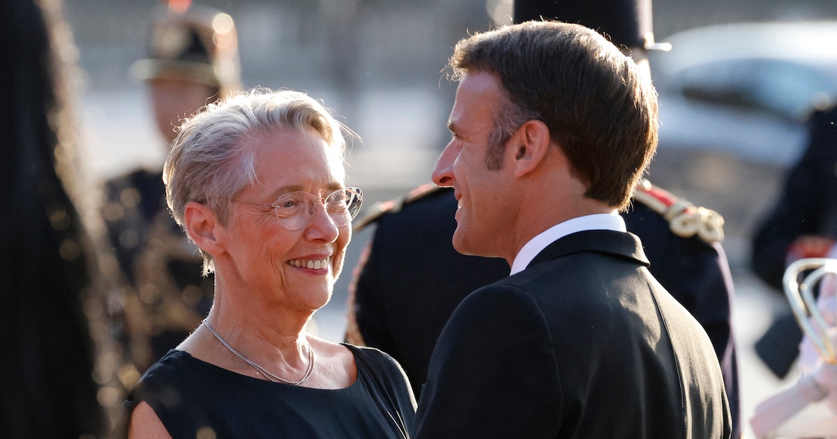 France's President Emmanuel Macron (R) and France's Prime Minister Elisabeth Borne chat as they wait for the arrival of the Indian Prime Minister ahead of a dinner at The Louvre Museum in Paris, on July 14, 2023. (Photo by Ludovic MARIN / AFP)