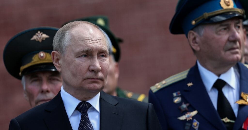 Le président russe Vladimir Poutine (g) participe à une cérémonie de dépôt de gerbes sur la tombe du Soldat inconnu près du mur du Kremlin, le 22 juin 2024 à Moscou