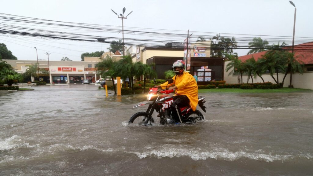 A motorcyclist in a flooded street in La Ceiba, Honduras. Pic: Reuters