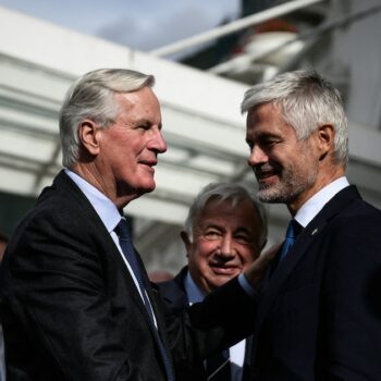 Le chef du groupe parlementaire des Républicains (LR) à l'Assemblée nationale, Laurent Wauquiez (au centre à droite) accueille le Premier ministre français Michel Barnier (au centre à gauche) alors que le président du Sénat français Gérard Larcher (au centre) assiste à l'arrivée de Barnier pour y participer aux Journées parlementaires du parti de droite Les Républicains (LR) à Annecy le 12 septembre 2024.