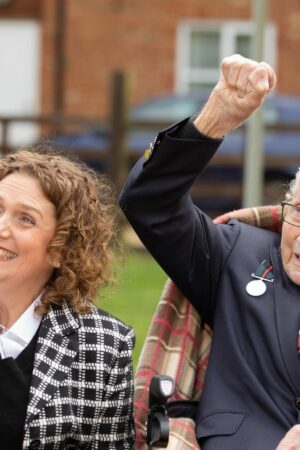 Handout photo of Second World War veteran Captain Tom Moore with his daughter Hannah, as they wave to a Battle of Britain Memorial Flight flypast of a Spitfire and a Hurricane passing over his home as he celebrates his 100th birthday.