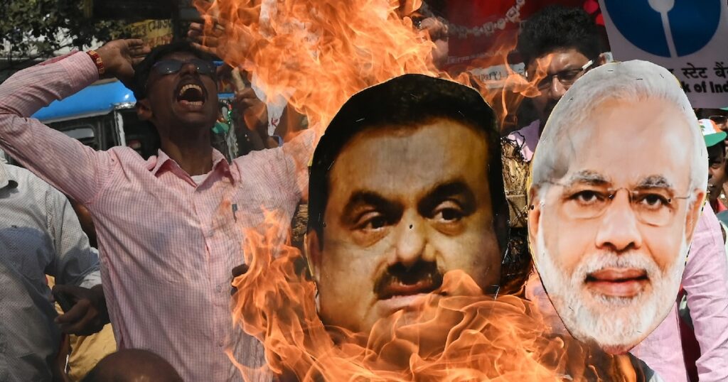 Un militant de l'opposition brûle les effigies du Premier ministre indien Narendra Modi et du milliardaire Gautam Adani pendant une manifestation à Calcutta, le 6 février 2023