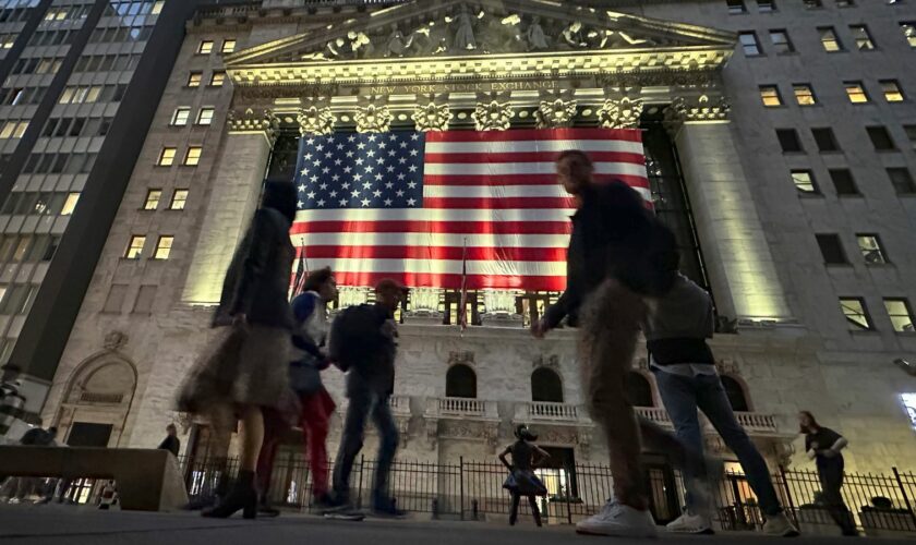 People pass the New York Stock Exchange in New York's Financial District on Tuesday, Nov. 5, 2024. (AP Photo/Peter Morgan)