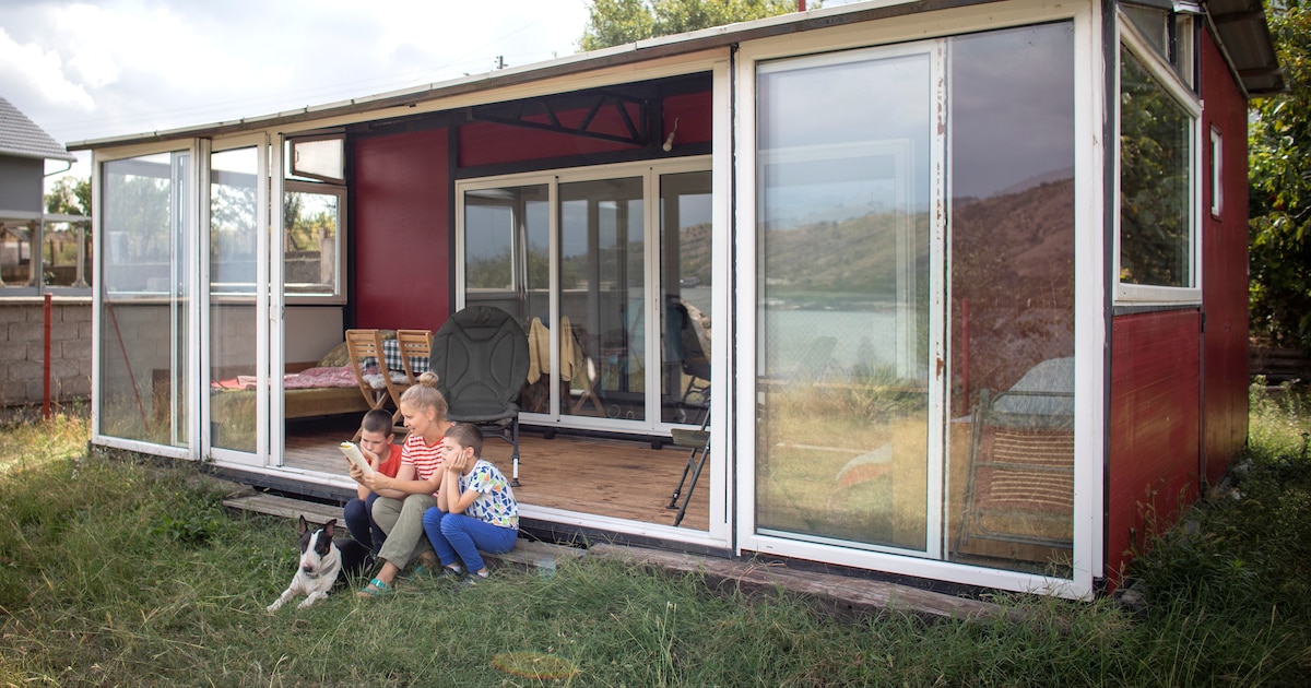 Une mère avec deux enfants et un chien profitant de leur maison-container.