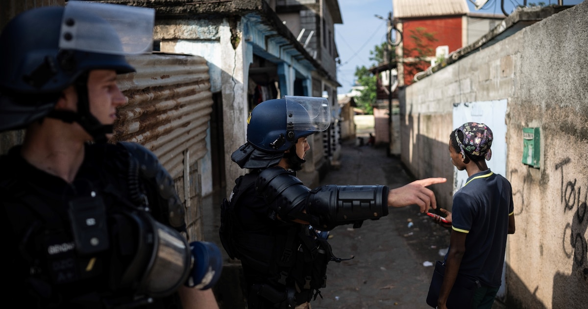 Des gendarmes contôlent un jeune garçon lors d'une opération de sécurité dans un bidonville à Koungou, à Mayotte, le 16 février 2024