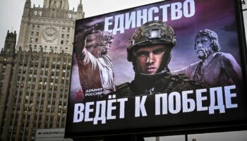 Le siège du mininstère russe des Affaires étrangères à Moscou vu derrière un panneau publicitaire de l'armée avec pour slogan "L'Unité mène à la Victoire!", le 21 novembre 2024