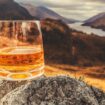 Glass of single malt Scotch Whisky on an old rock above Glenfinnan in the West Highlands of Scotland.