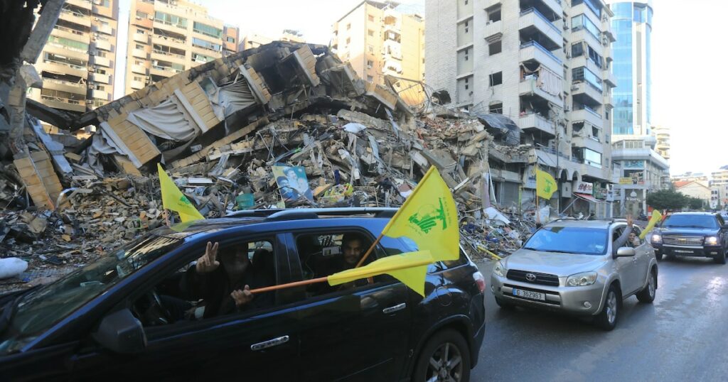 Des automobilistes défilent avec le drapeau du Hezbollah dans la banlieue sud de Beyrouth, après l'entrée en vigueur d'un cessez-le-feu entre Israël et le Hezbollah, le 27 novembre 2024 au Liban