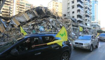 Des automobilistes défilent avec le drapeau du Hezbollah dans la banlieue sud de Beyrouth, après l'entrée en vigueur d'un cessez-le-feu entre Israël et le Hezbollah, le 27 novembre 2024 au Liban