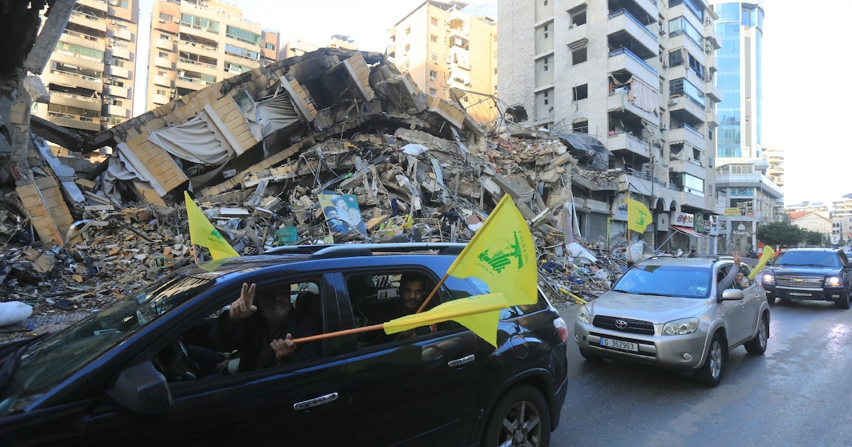 Des automobilistes défilent avec le drapeau du Hezbollah dans la banlieue sud de Beyrouth, après l'entrée en vigueur d'un cessez-le-feu entre Israël et le Hezbollah, le 27 novembre 2024 au Liban