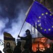 A protester brandishes an EU flag as demonstrations continue in Tbilisi on Saturday. Pic: Reuters