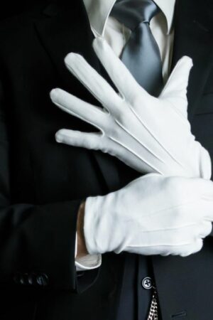 Ein Butler zieht weiße Handschuhe an