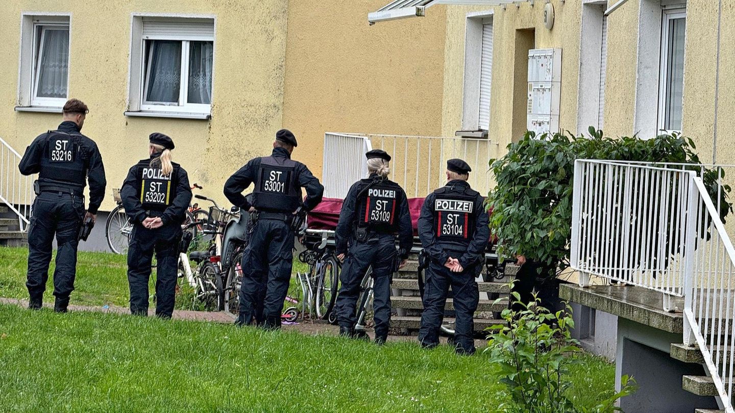 Fünf Polizistinnen und Polizisten stehen vor einem Haus