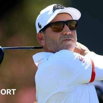 Sergio Garcia in sunglasses with a golf club after taking a shot