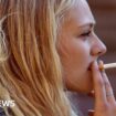 Blonde woman smoking cigarette - stock photo