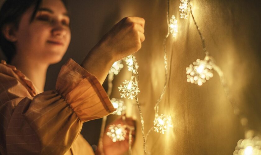 EIne Frau hängt Lichterketten auf