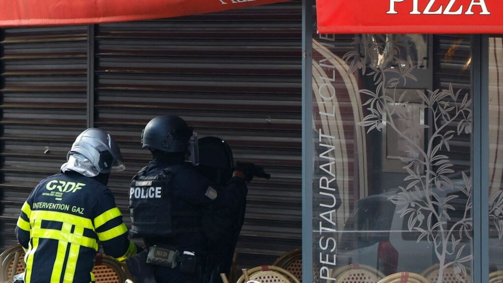 Polizisten stehen vor dem Restaurant in Issy-les-Moulineaux. Foto: Ian Langsdon/AFP/dpa