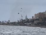 Shocking moment tornado sends debris flying on Malaga beach as footage shows the Costa del Sol hit by water spouts, floods and torrential rain in latest storms to hit Spain