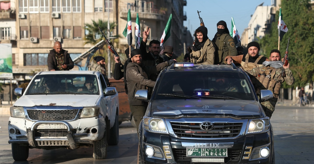 Des combattants antigouvernementaux brandissent des armes dans la ville d'Alep, dans le nord de la Syrie, le 30 novembre 2024