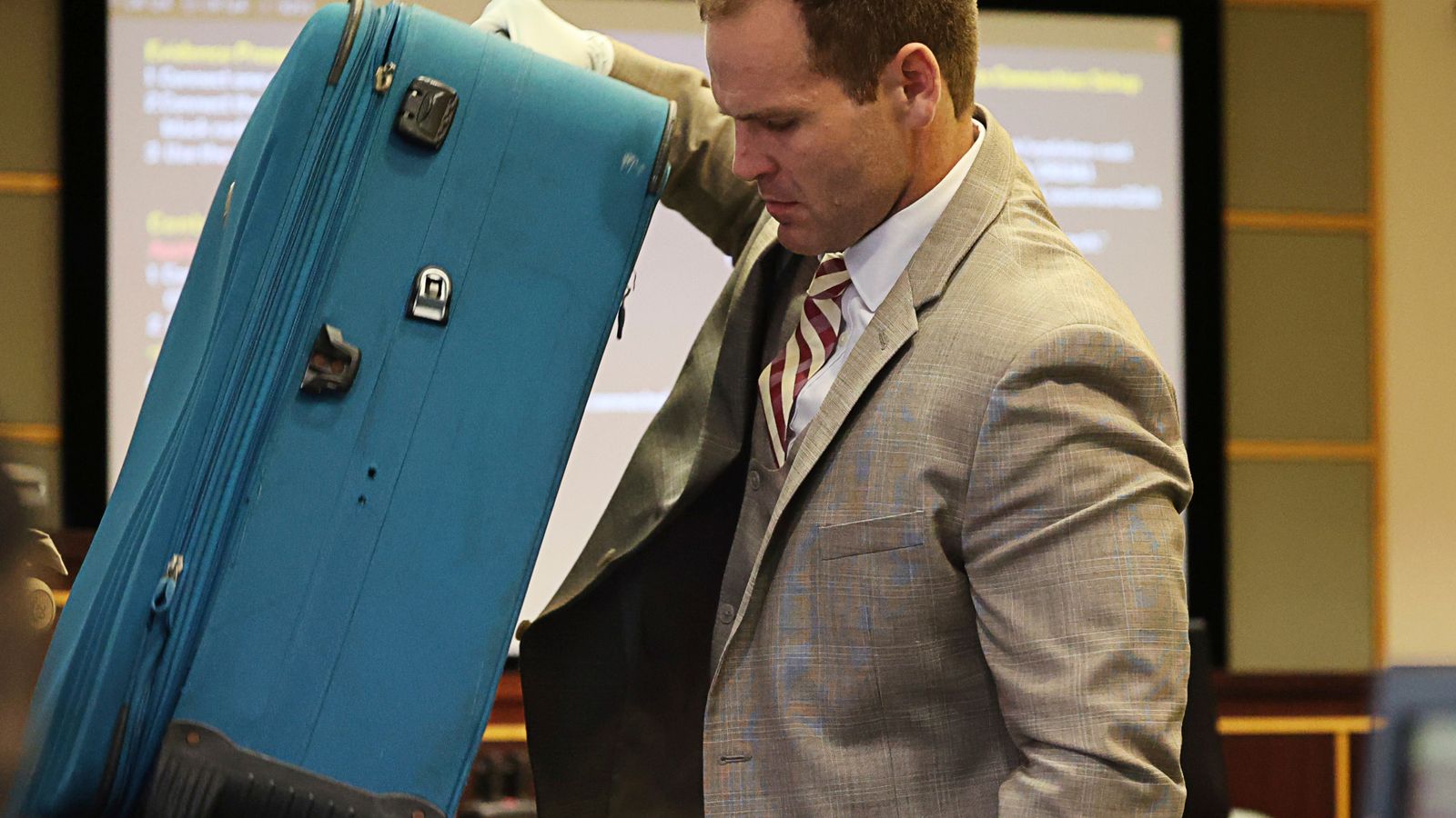 Prosecutor Dave Cacciatore Jr. takes out the suitcase in evidence as he begins the closing arguments in Defendant Sarah Boone's trial, Friday, Oct. 25, 2024, at the Orange County Courthouse in Orlando, Fla. Boone is charged with leaving her boyfriend to die after he was zipped into a suitcase in their home,  (Ricardo Ramirez Buxeda/Orlando Sentinel via AP, Pool)