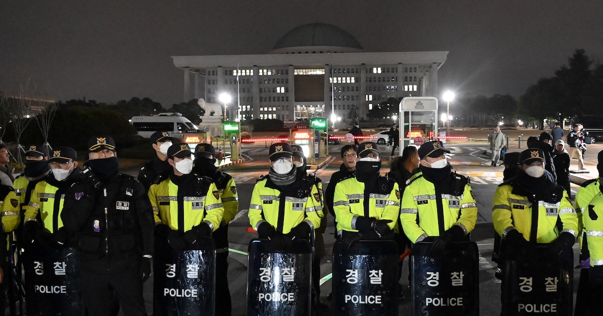 La police monte la garde devant la porte principale de l'Assemblée nationale à Séoul le 3 décembre 2024, après que le président sud-coréen Yoon Suk Yeol a déclaré la loi martiale d'urgence.