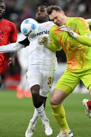 Manuel Neuer kommt zu spät und rammt Leverkusens Jeremie Frimpong um. Foto: Sven Hoppe/dpa