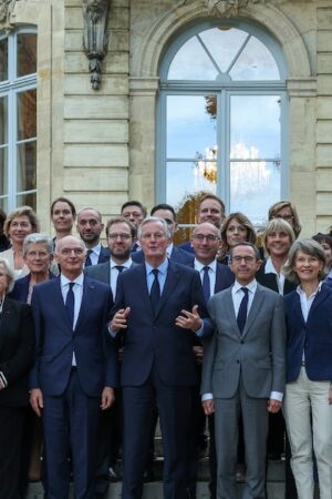 Le Premier ministre Michel Barnier (au centre, mains levées) entouré des membres de son gouvernement à l'issue d'un séminaire à Matignon, à Paris, le 27 septembre 2024