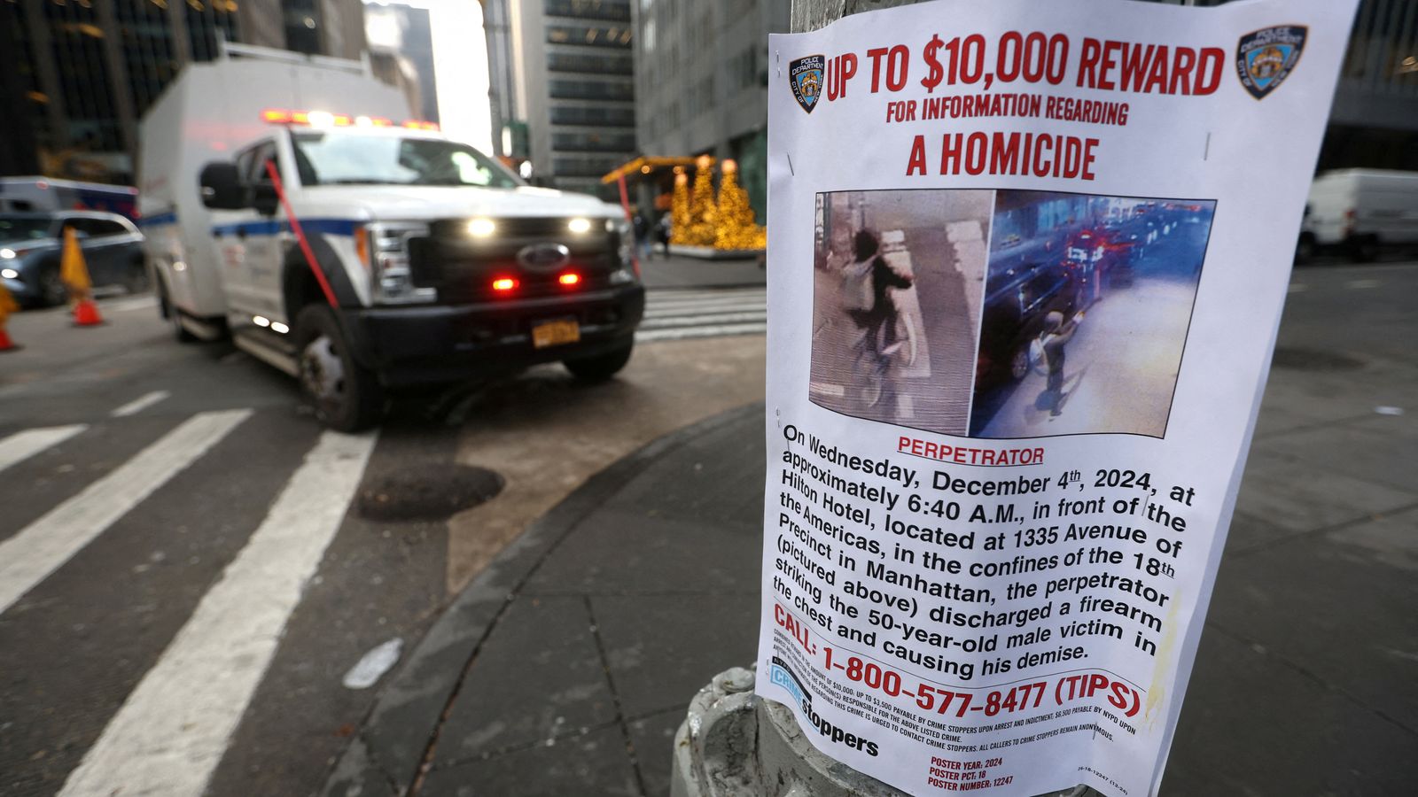 A poster is attached to a lamp post outside the Hilton hotel near the scene where the CEO of UnitedHealthcare Brian Thompson was shot