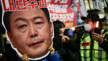 Un manifestant brandit un portrait du président sud-coréen Yoon Suk Yeol, lors d'un rassemblement pour sa démission, le 8 décembre 2024 à Séoul