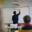 A teacher wearing a protective face mask works with pupils after they have returned to their classroom at the Trinite public school in the Groix island, on May 12, 2020, two days after France eased lockdown measures to curb the spread of the COVID-19 pandemic, caused by the novel coronavirus. (Photo by Loic VENANCE / AFP)