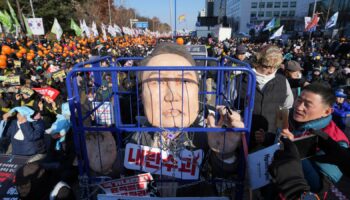 A caricature of South Korea's president is seen behind bars as protesters gathered to demand his impeachment today. Pic: AP